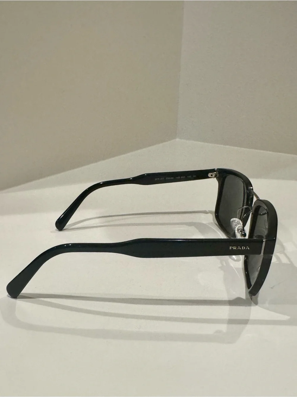 Prada SPR 14T Black unisex sunglasses with silver accents.